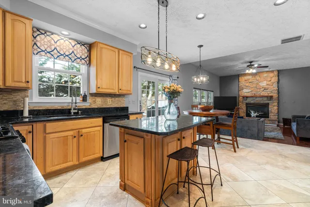 a kitchen with stainless steel appliances granite countertop table chairs and a large window