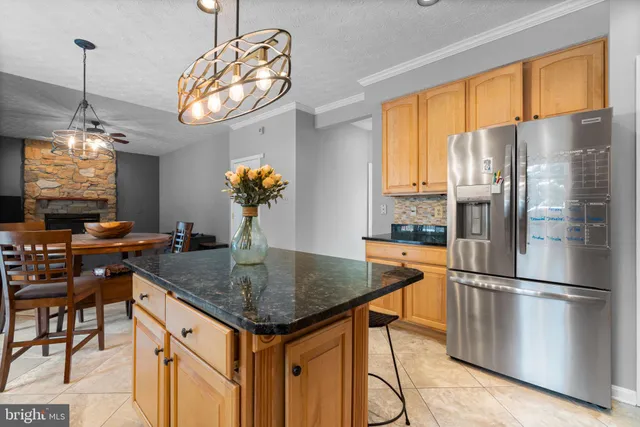 a kitchen with stainless steel appliances granite countertop a sink refrigerator and microwave