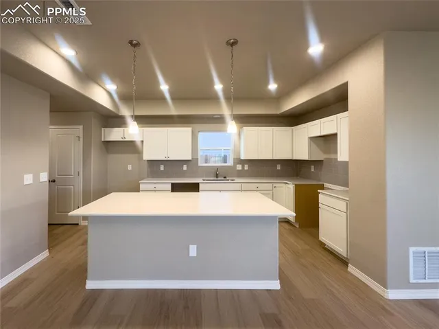 a large kitchen with kitchen island a stove a sink a refrigerator and cabinets