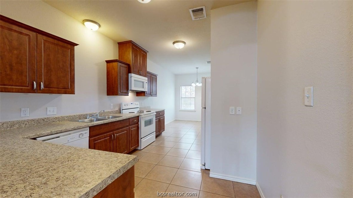 4453-4455 Reveille Road College Station, TX 77845 - Photo 24 of 37 a kitchen with stainless steel appliances granite countertop a sink and a stove top oven