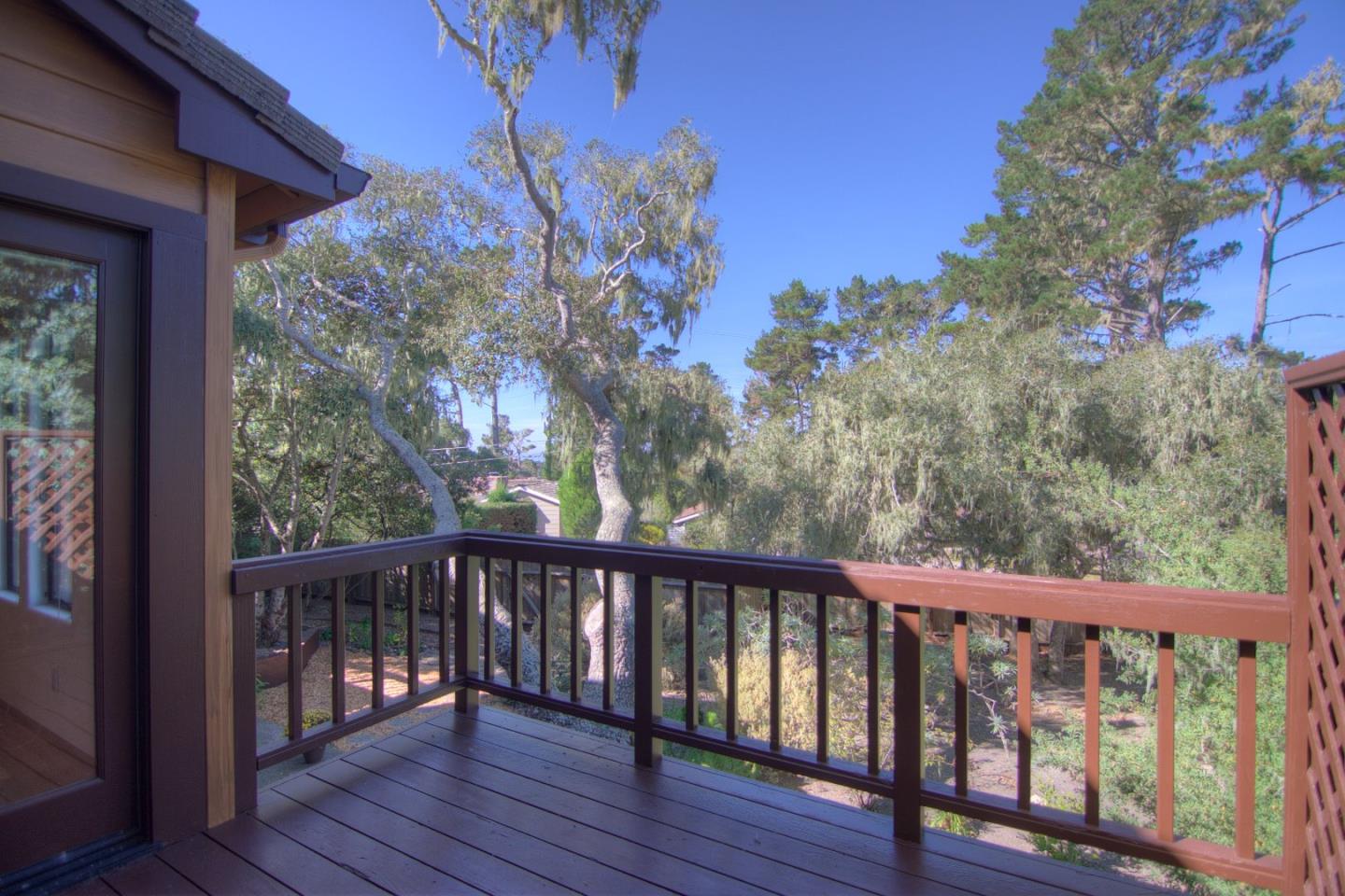 3062 Sloat Road Pebble Beach, CA 93953 - Photo 3 of 24 a balcony with wooden floor and trees in the back