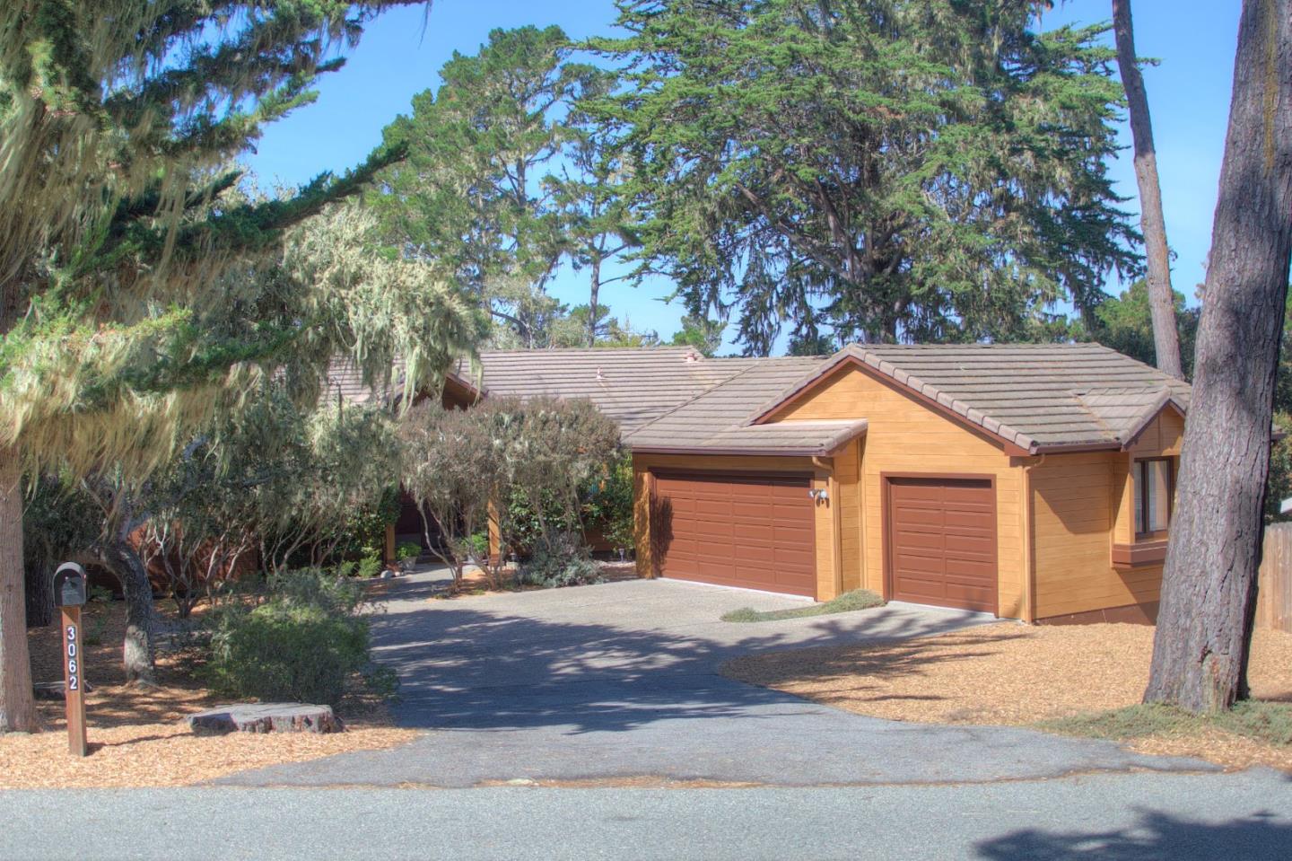 3062 Sloat Road Pebble Beach, CA 93953 - Photo 4 of 24 a backyard of a house with large trees and plants
