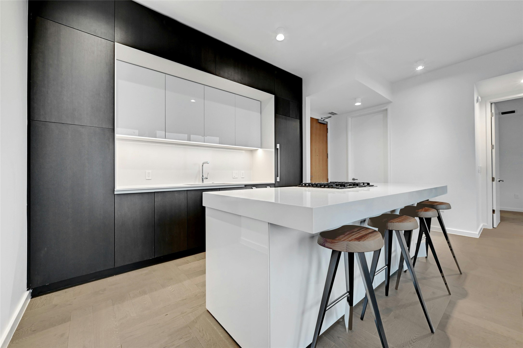 313 West 17th Street, Unit 2306 Austin, TX 78701 - Photo 5 of 35 Sleek kitchen with integrated appliances, custom cabinetry and a large waterfall island with bar seating. Furnishings provided by Scott + Cooner available for purchase separately.