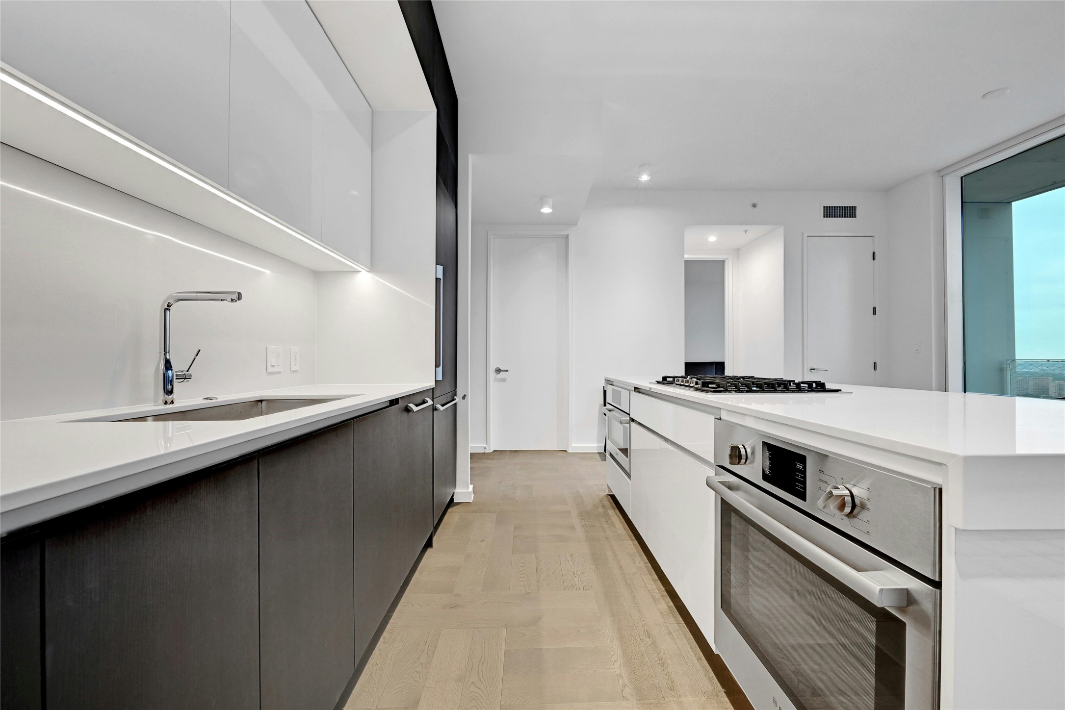 313 West 17th Street, Unit 2306 Austin, TX 78701 - Photo 6 of 35 Modern kitchen with sleek cabinetry, integrated Bosch® appliances and a waterfall island with gas cooktop.
