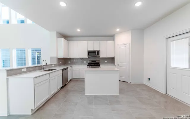 a kitchen with granite countertop white cabinets and white appliances