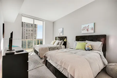 a bedroom with two beds and a large window