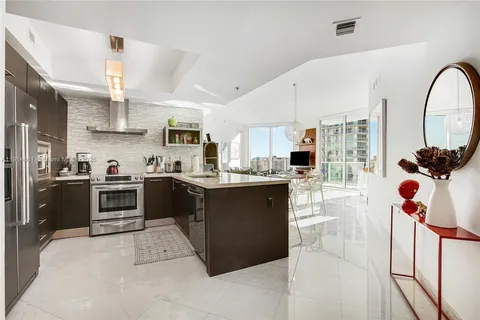 a kitchen with stainless steel appliances kitchen island granite countertop a stove a sink a refrigerator and a microwave