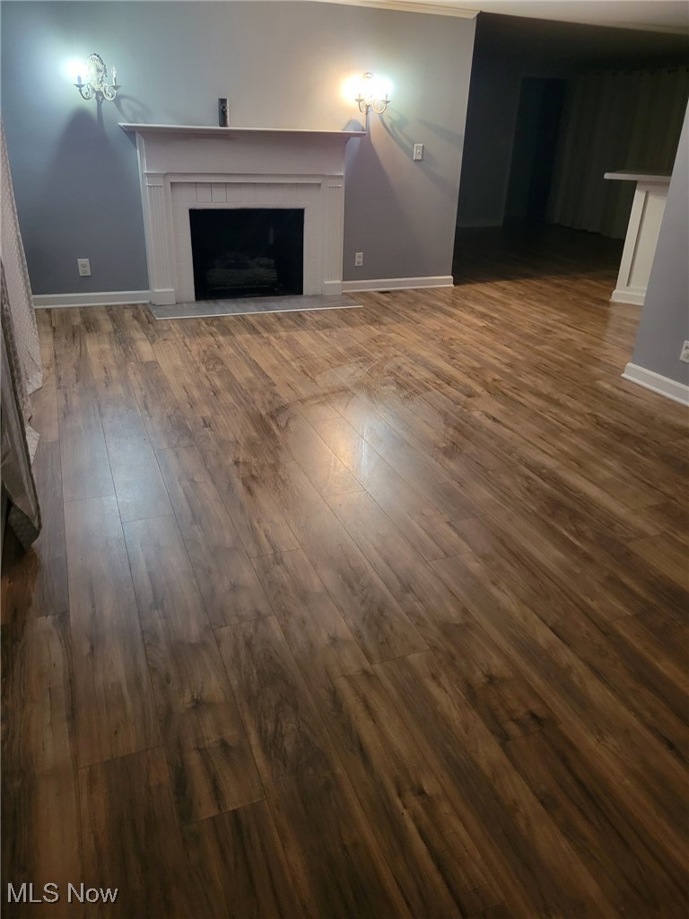 2440 Midvale Road Northwest Canton, OH 44708 - Photo 7 of 22 Unfurnished living room featuring dark hardwood / wood-style floors and a tile fireplace