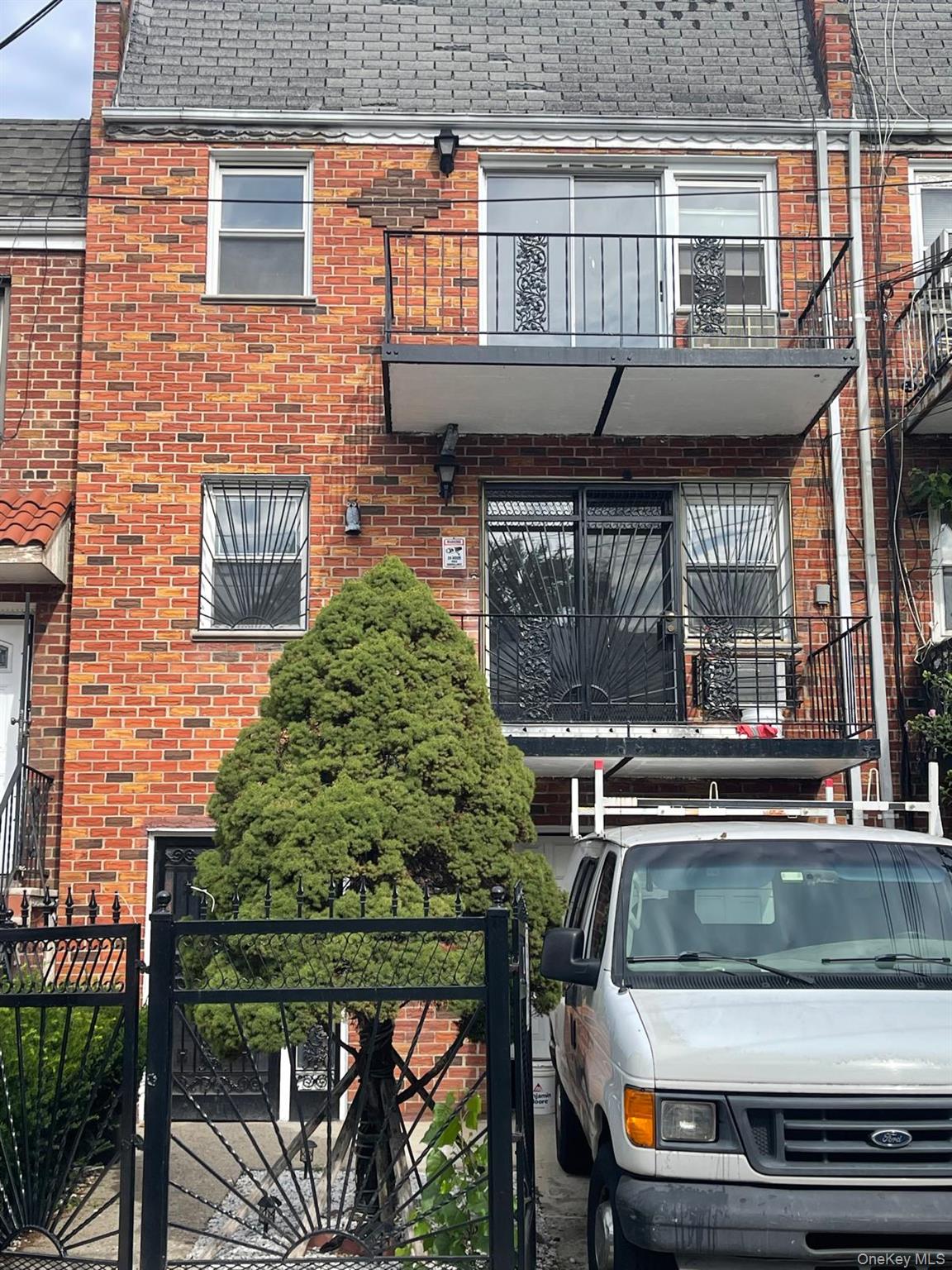 a view of a house with a balcony and car parked