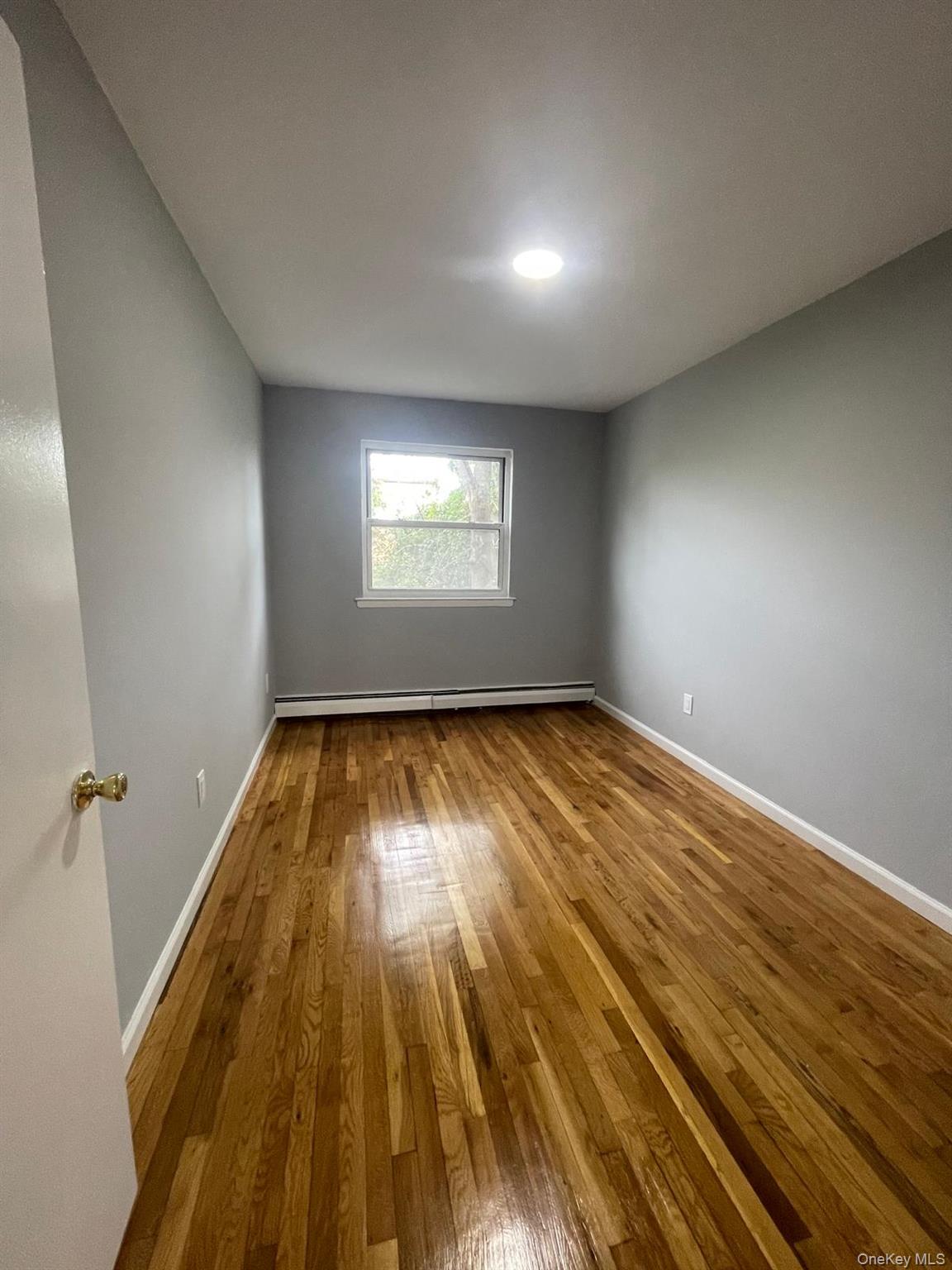 110-21 55th Avenue Queens, NY 11368 - Photo 17 of 29 an empty room with wooden floor and windows