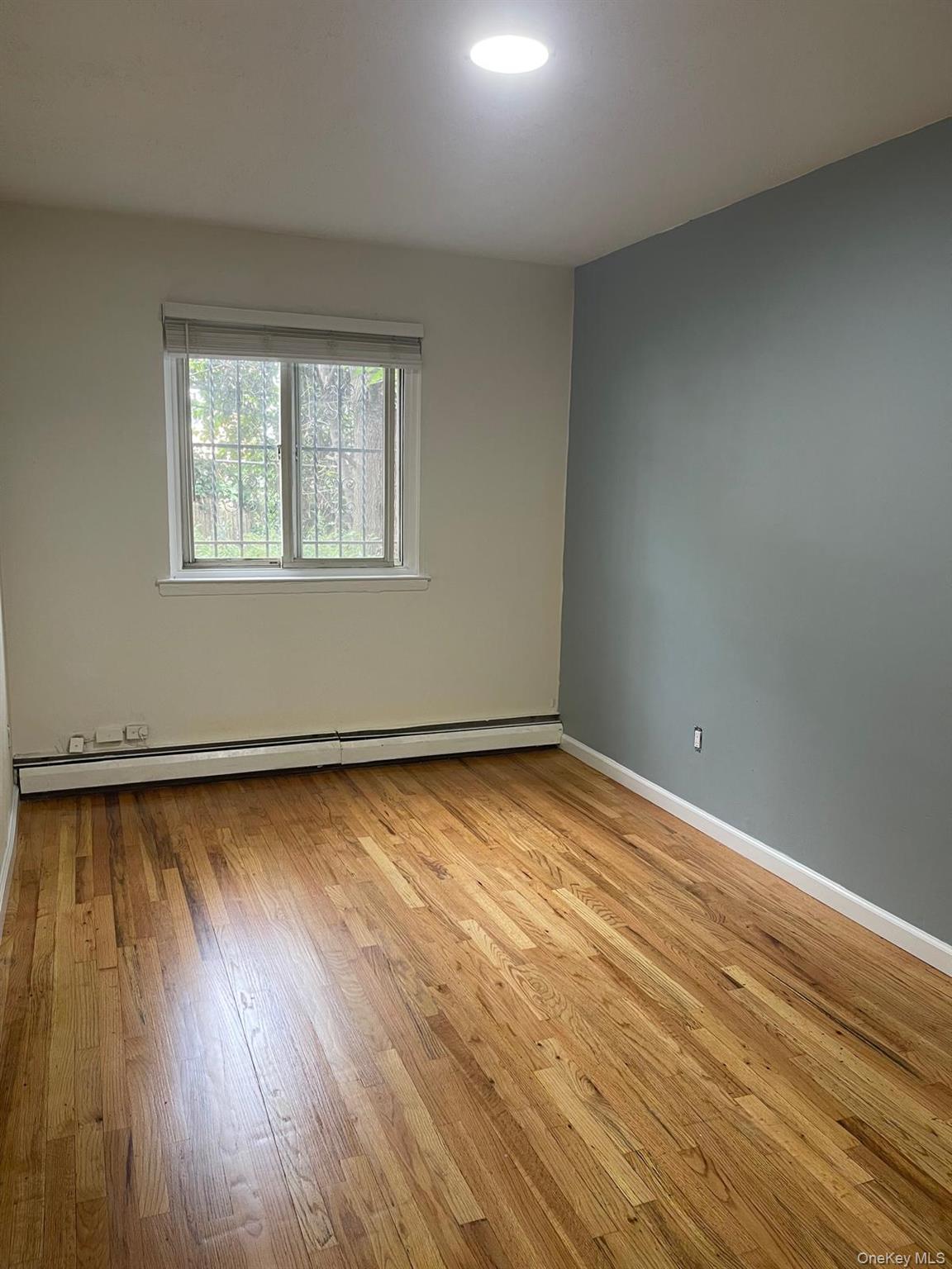 110-21 55th Avenue Queens, NY 11368 - Photo 8 of 29 wooden floor in an empty room with a window