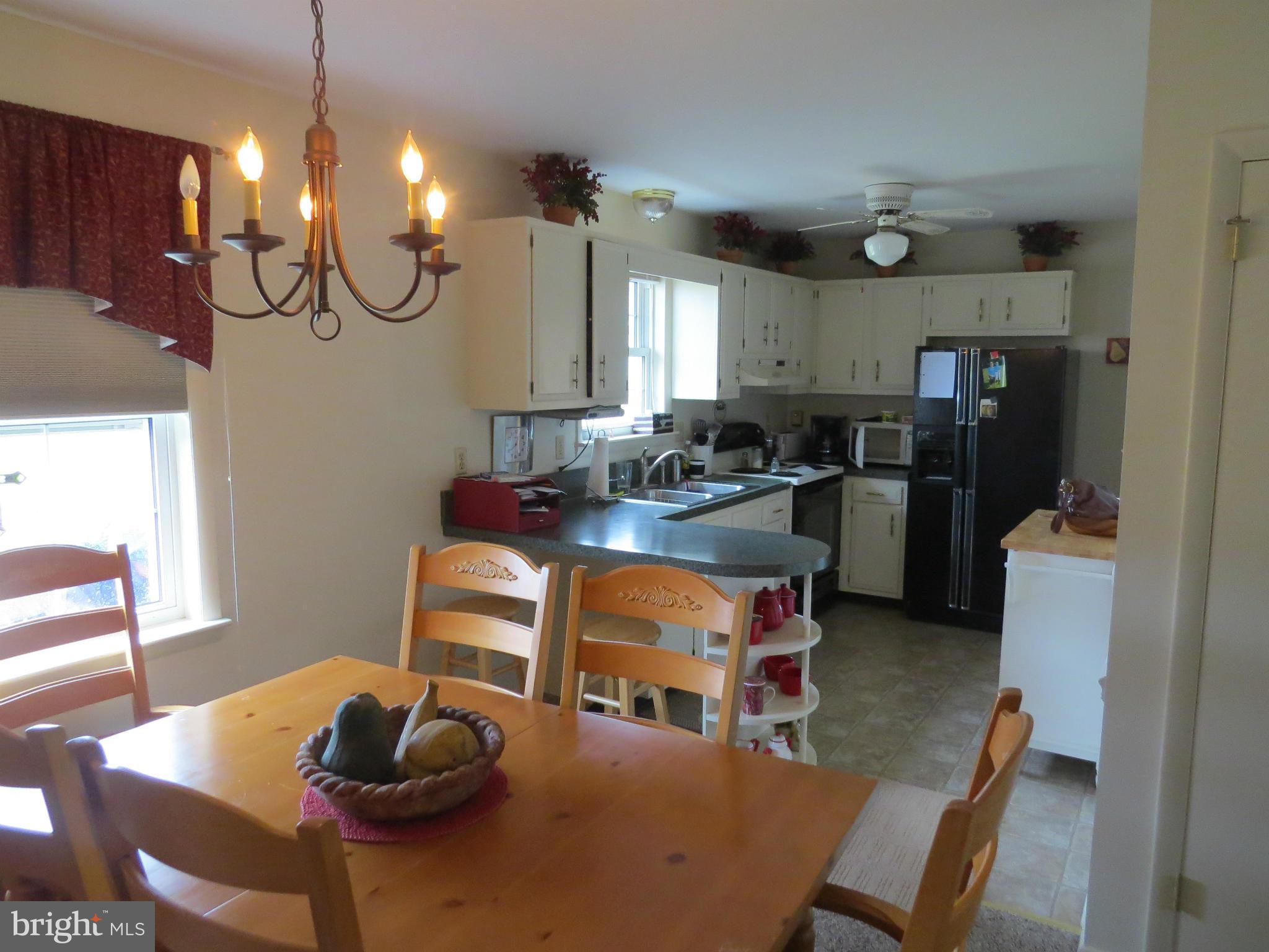 11922 Big Spring Road Clear Spring, MD 21722 - Photo 3 of 17 a living room with furniture a dining table and a chandelier