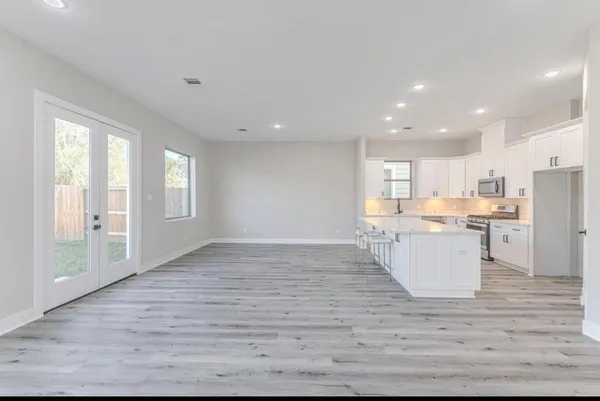 a kitchen with stainless steel appliances granite countertop a sink refrigerator and cabinets