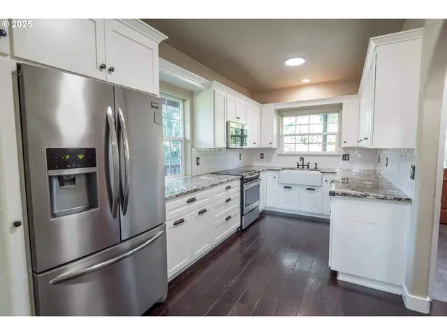 a kitchen with a refrigerator sink and cabinets
