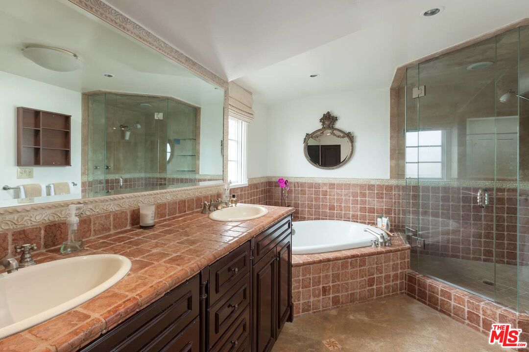 703 Palisades Beach Road Santa Monica, CA 90402 - Photo 32 of 37 a bathroom with a granite countertop tub a sink and a mirror