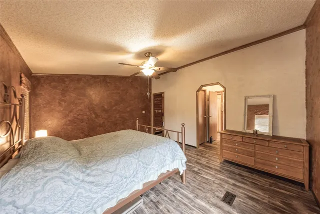 a bedroom with a bed and a mirror on dresser