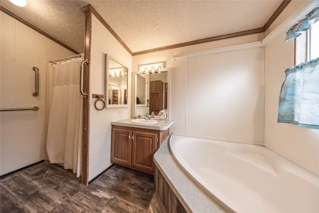 a bathroom with a tub sink shower and mirror
