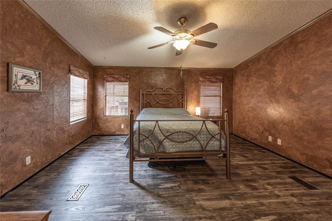 715 Bee Gee Road Driftwood, TX 78619 - Photo 15 of 40 a bedroom with a bed and a chandelier