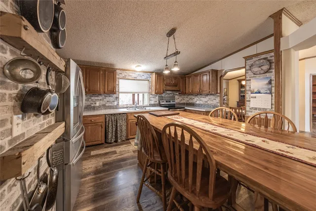 a kitchen with granite countertop a sink a counter space appliances and cabinets