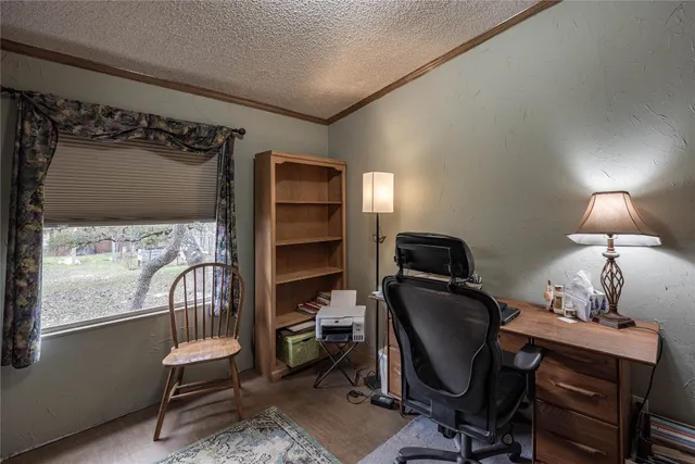 a view of a workspace with furniture and a window