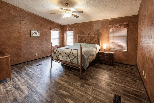 a spacious bedroom with a bed and wooden floor