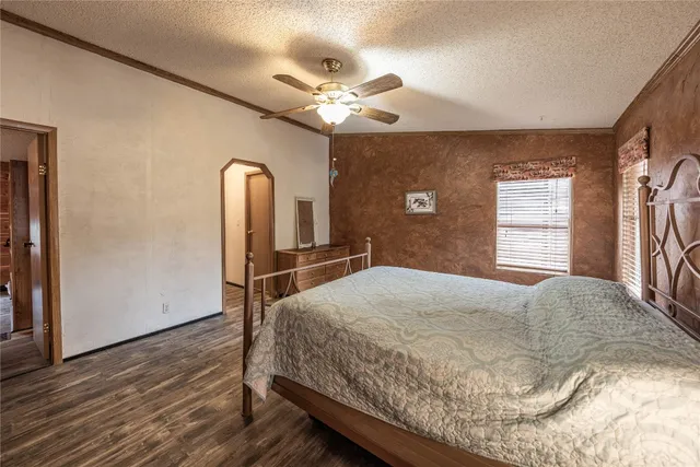 a bedroom with a large bed and a chandelier
