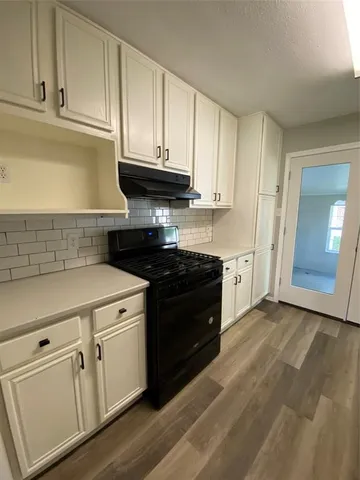 a kitchen with granite countertop white cabinets and black appliances
