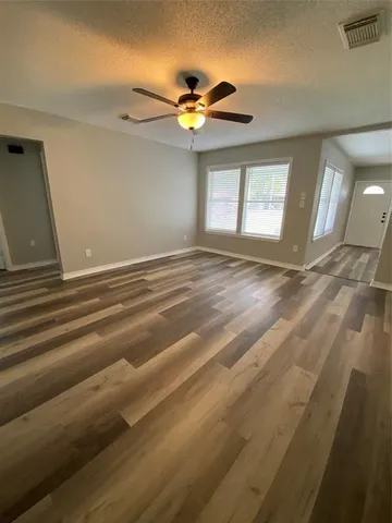 a view of empty room with window and ceiling fan