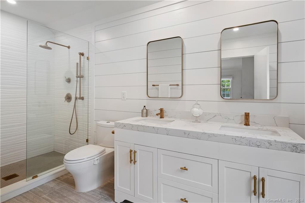 782 Smith Ridge Road New Canaan, CT 06840 - Photo 20 of 28 a bathroom with a granite countertop toilet sink shower and mirror