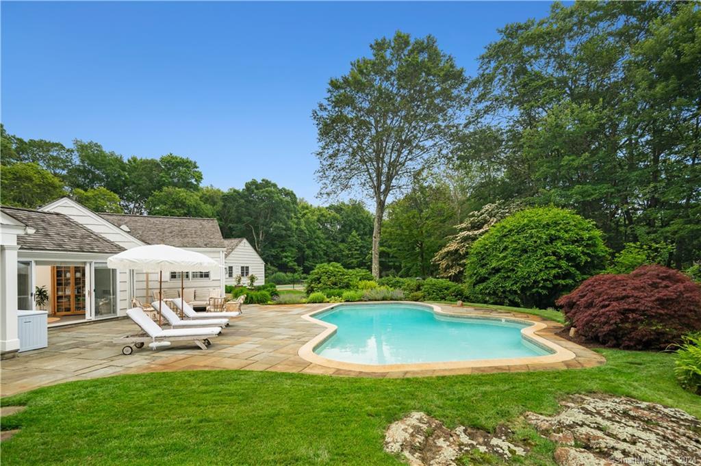 782 Smith Ridge Road New Canaan, CT 06840 - Photo 26 of 28 a view of a white house with a swimming pool and sitting area