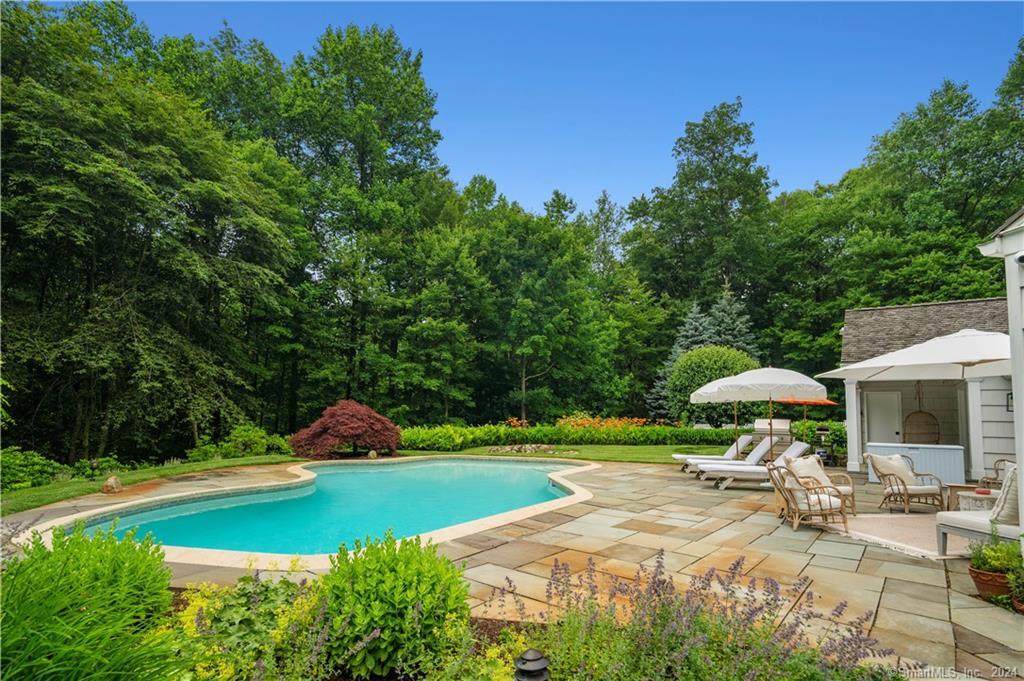782 Smith Ridge Road New Canaan, CT 06840 - Photo 6 of 28 a view of a patio with a table and chairs under an umbrella