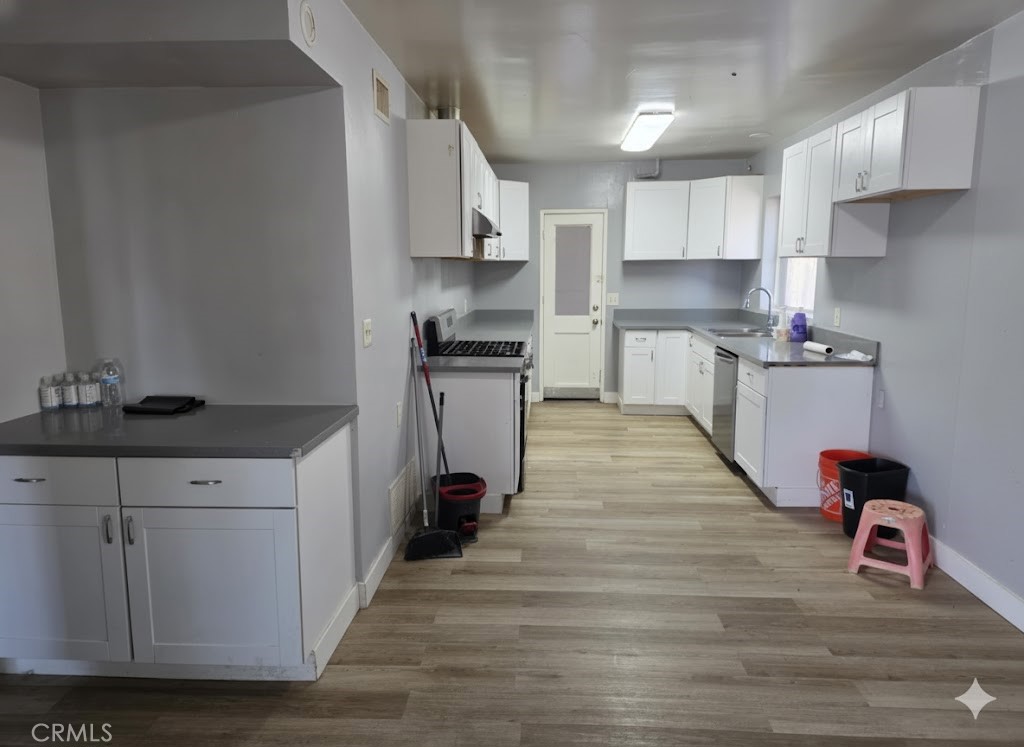 7072 Kermore Lane Stanton, CA 90680 - Photo 6 of 24 a kitchen with stainless steel appliances granite countertop a kitchen island hardwood floor sink and stove