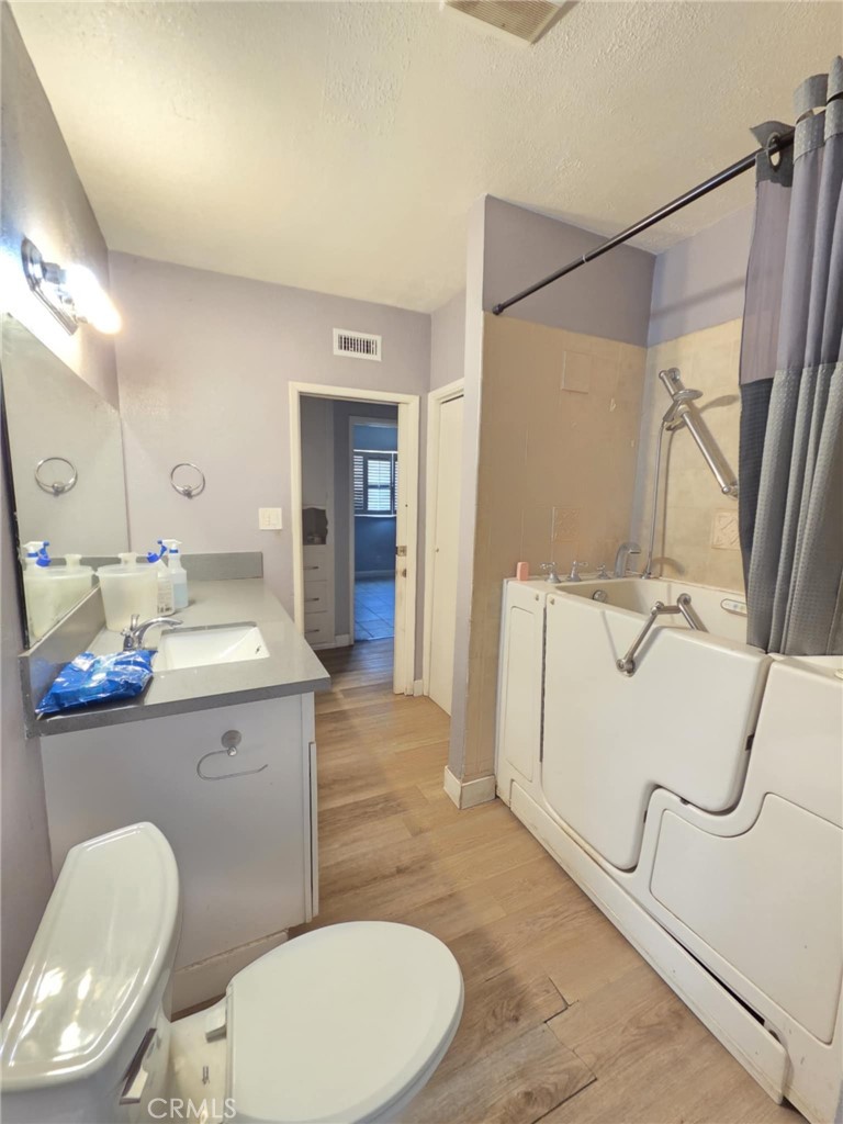 7072 Kermore Lane Stanton, CA 90680 - Photo 10 of 24 a bathroom with a granite countertop toilet sink and mirror