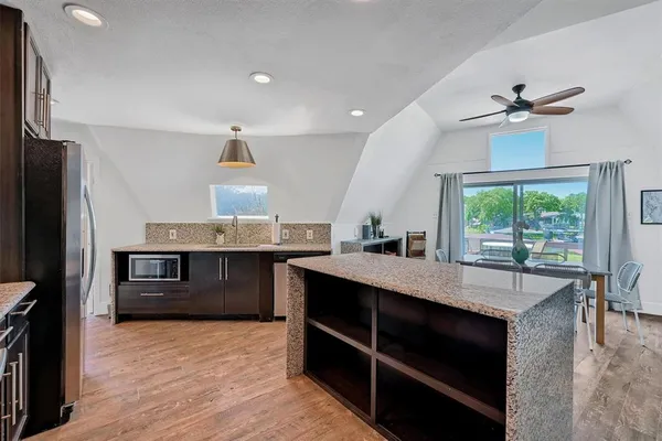 a kitchen with kitchen island granite countertop a stove refrigerator and cabinets