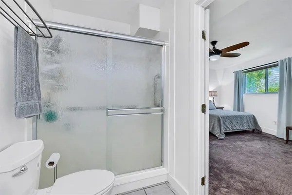 a bathroom with a shower a toilet and a shower