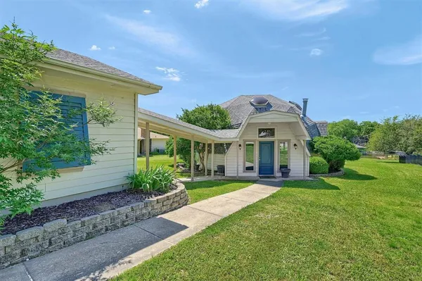 a front view of a house with a yard and potted plants