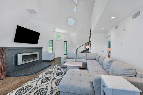 a living room with furniture a fireplace and a flat screen tv