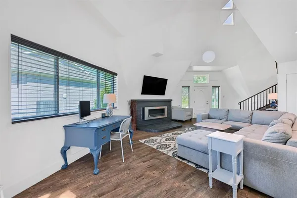 a living room with furniture a fireplace and a flat screen tv