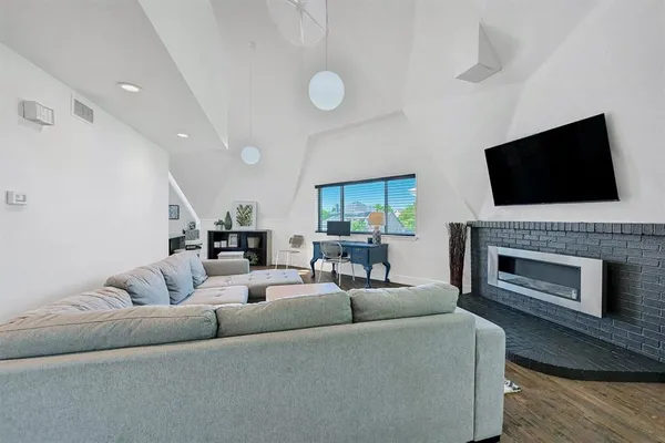 a living room with furniture a fireplace and a flat screen tv