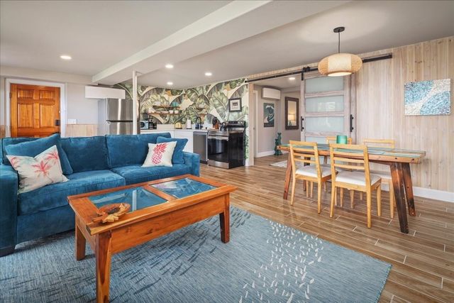 a living room with furniture a dining table and chairs with wooden floor