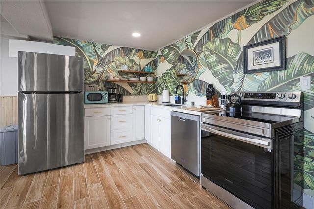 a kitchen with stainless steel appliances a stove a refrigerator and a sink