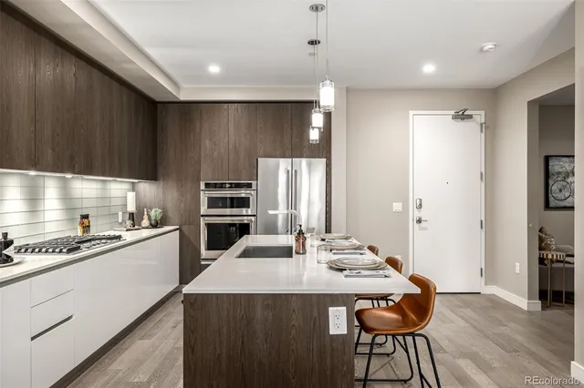 a kitchen with kitchen island a stove a table and chairs in it