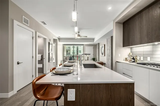 a kitchen with sink refrigerator dining table and chairs