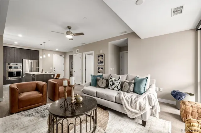 a living room with furniture and a view of kitchen