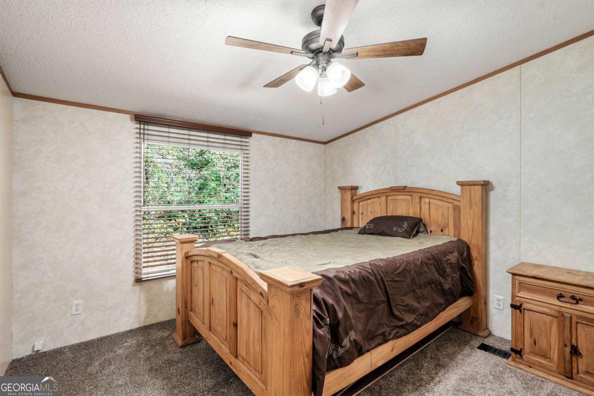 359 Norton Bridge Road Chatsworth, GA 30705 - Photo 11 of 28 a bedroom with a bed and a ceiling fan