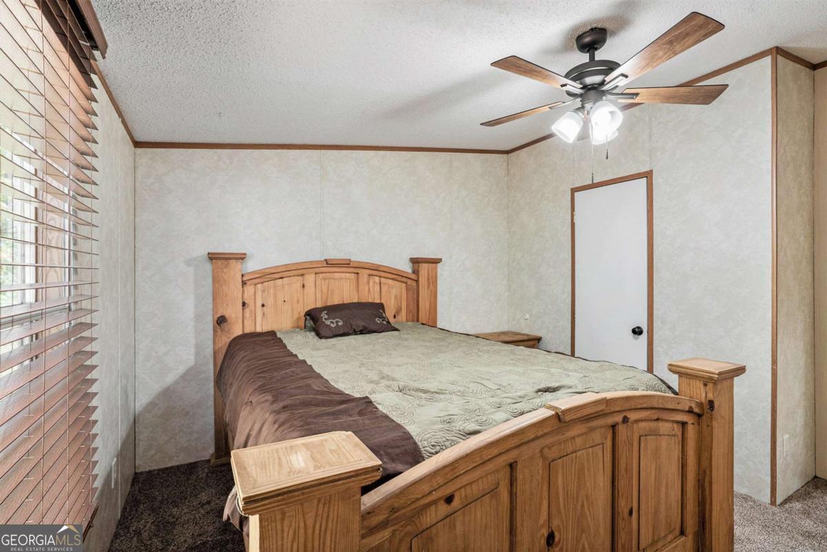 359 Norton Bridge Road Chatsworth, GA 30705 - Photo 12 of 28 a bedroom with a bed and a chandelier