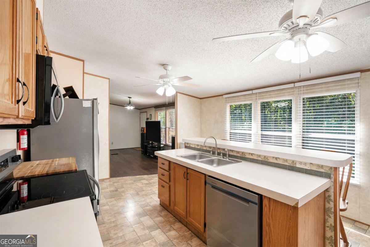 359 Norton Bridge Road Chatsworth, GA 30705 - Photo 13 of 28 a kitchen with a stove a refrigerator and a sink