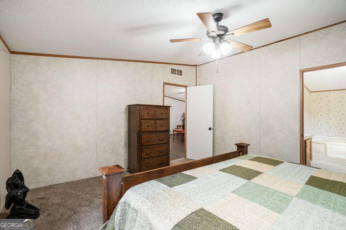 359 Norton Bridge Road Chatsworth, GA 30705 - Photo 7 of 28 a bedroom with a bed and a chandelier