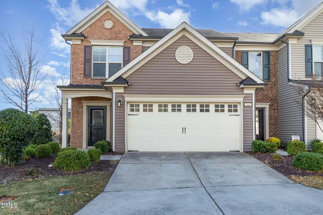 a view of a white house with a large windows and flower plants