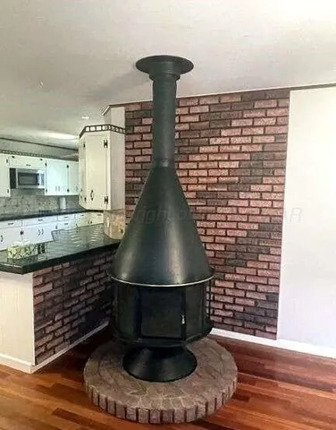 a view of a living room and kitchen with furniture wooden floor